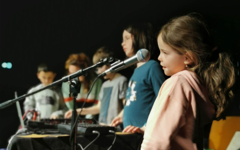 Atelier EAC - les enfants chantent devant un micro